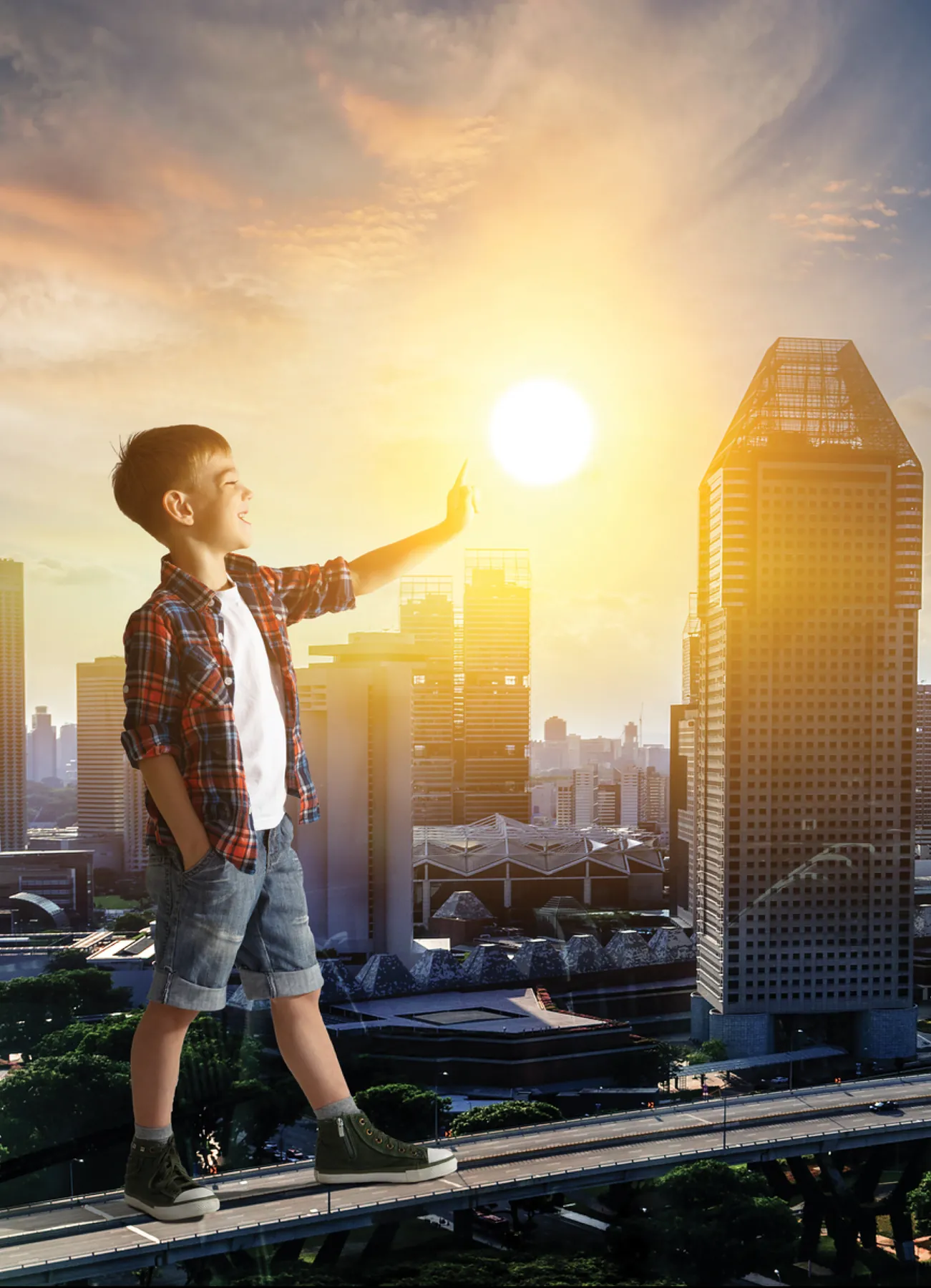 A boy reaching towards the sun above a city skyline