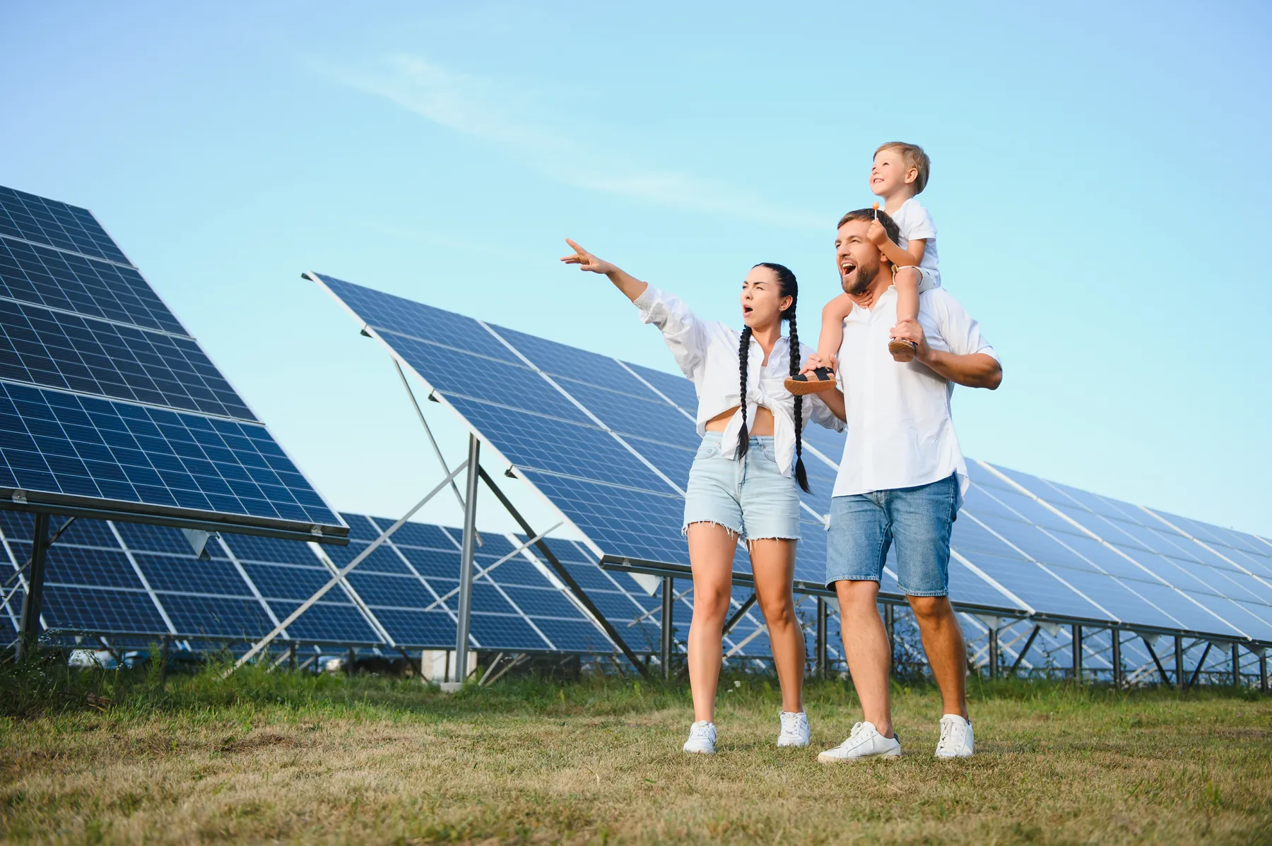 A young family beside solar panels