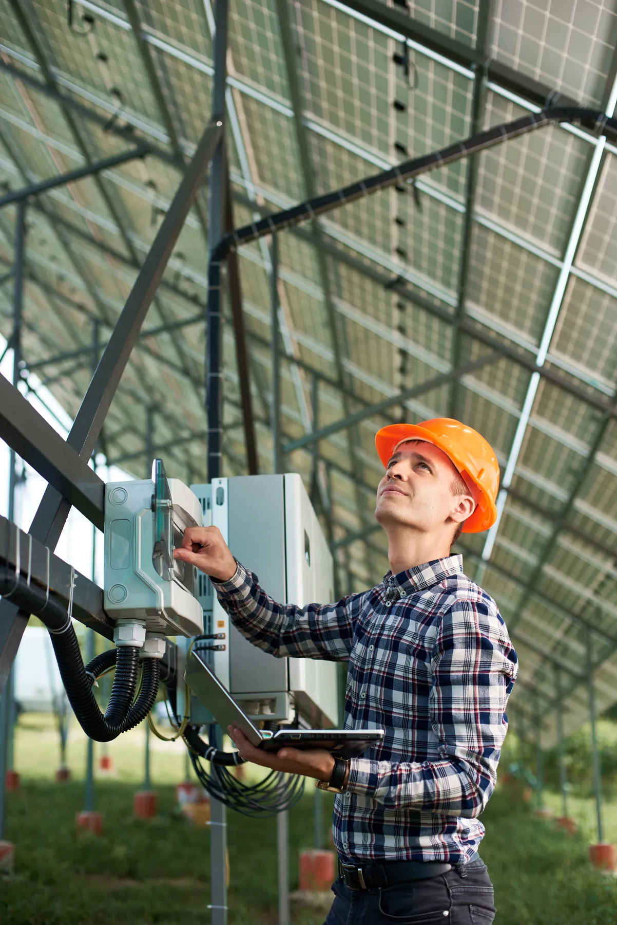 Engineer with a laptop at a solar station